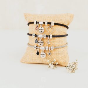 Pulsera plata super mamá personalizada con charms y medalla grabada sobre cojín yute