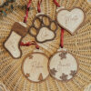 Bolas de Navidad personalizadas de madera con nombres grabados: calcetín, corazón, huella mascota, bola con copos y estrellas sobre base de mimbre