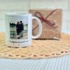 Taza blanca personalizada con foto de pareja y texto 'te elegiría una y mil veces', junto a caja regalo kraft con lazo rojo