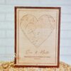 Cuadro mapa estelar personalizado grabado en madera con corazón de constelaciones, nombres Eric y Marta, frase 'Bajo este cielo comenzó todo' y fecha 17.04.2024, marco bicolor, sobre fondo neutro