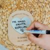 Pizarra de mensajes personalizada Razones con nombres Alex y Judith grabados, corazón borrable con texto 'me haces sentir especial', mano escribiendo con rotulador sobre fondo de mimbre