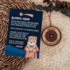 Botón perdido de los Reyes Magos personalizado en madera de arce con carta de Melchor sobre fondo navideño con eucalipto