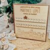 Calendario de Adviento de madera personalizado con apellidos Martínez López, 24 chapas numeradas y diseño de casitas navideñas grabadas a láser