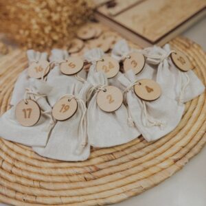 Las 24 chapas numeradas del calendario de adviento sobre bolsitas de tela (las bolsitas no se incluyen)