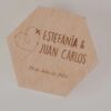 Porta alianzas hexagonal de madera personalizado con nombres Estefanía y Juan Carlos, fecha de boda y diseño de avión trazando corazón grabado a láser