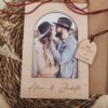 Tarjeta Sant Jordi de madera personalizada con foto de pareja, sobre kraft y etiqueta grabada con nombres y fecha